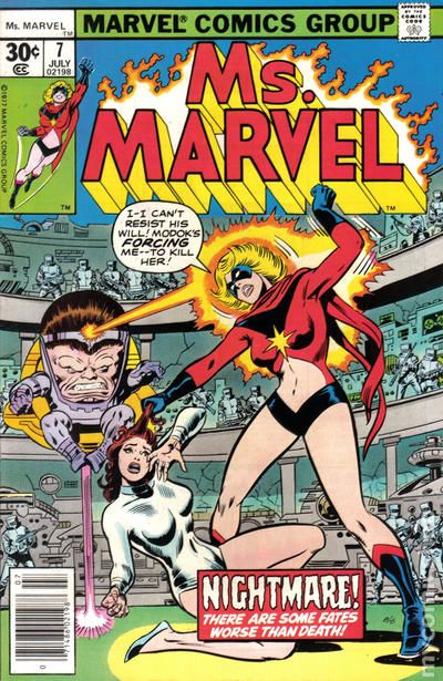 aware blonde_hair bodysuit breasts carol_danvers cover dialogue eye_mask femsub large_breasts maledom marvel_comics modok ms._marvel official screenshot short_hair super_hero tech_control text